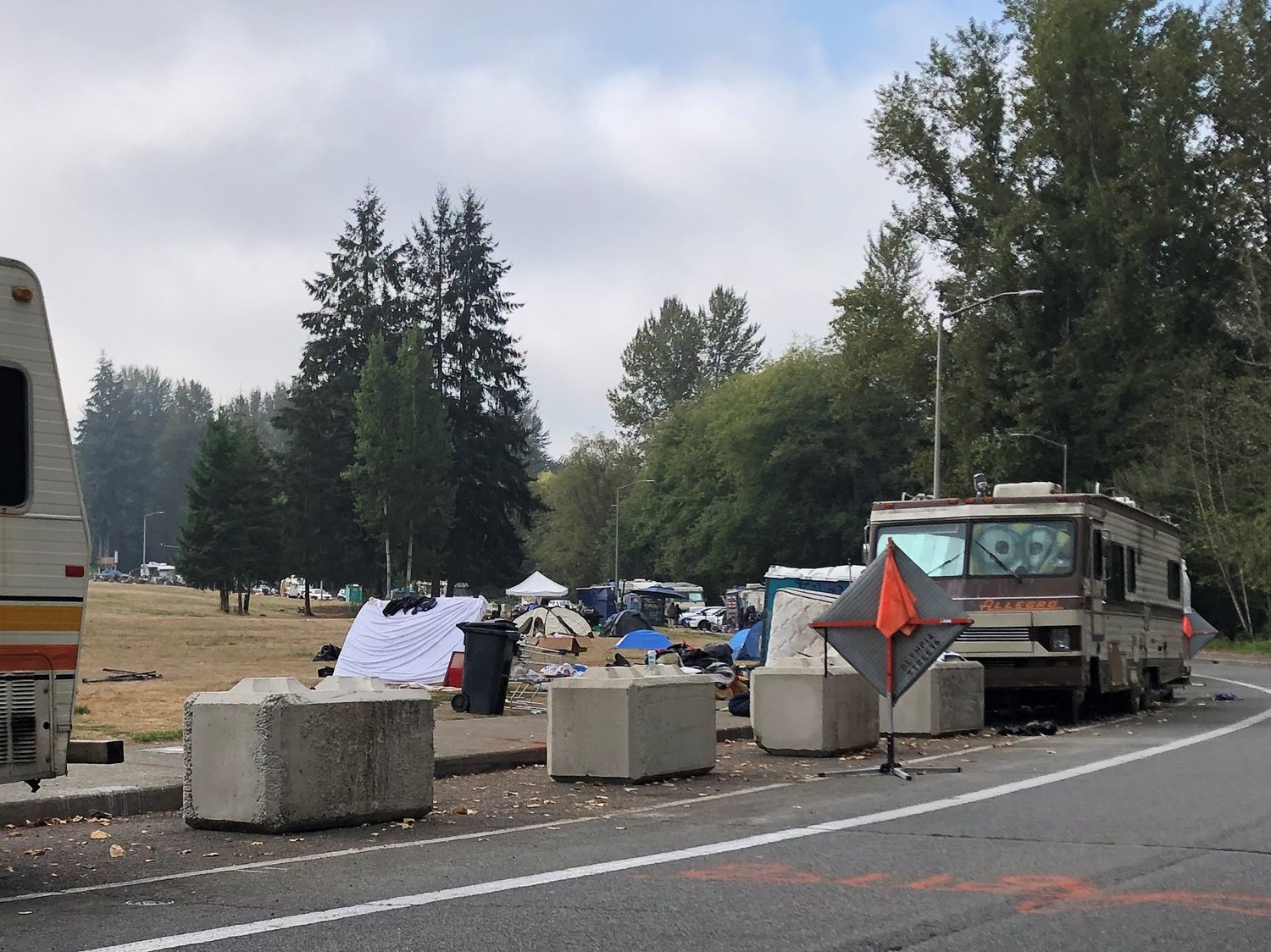 This was part of the Ensign Road Homeless Encampment on October 3, 2022, with tents and debris spread across sections of the field next to the road.